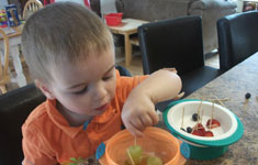 Boy eating from orange bowl